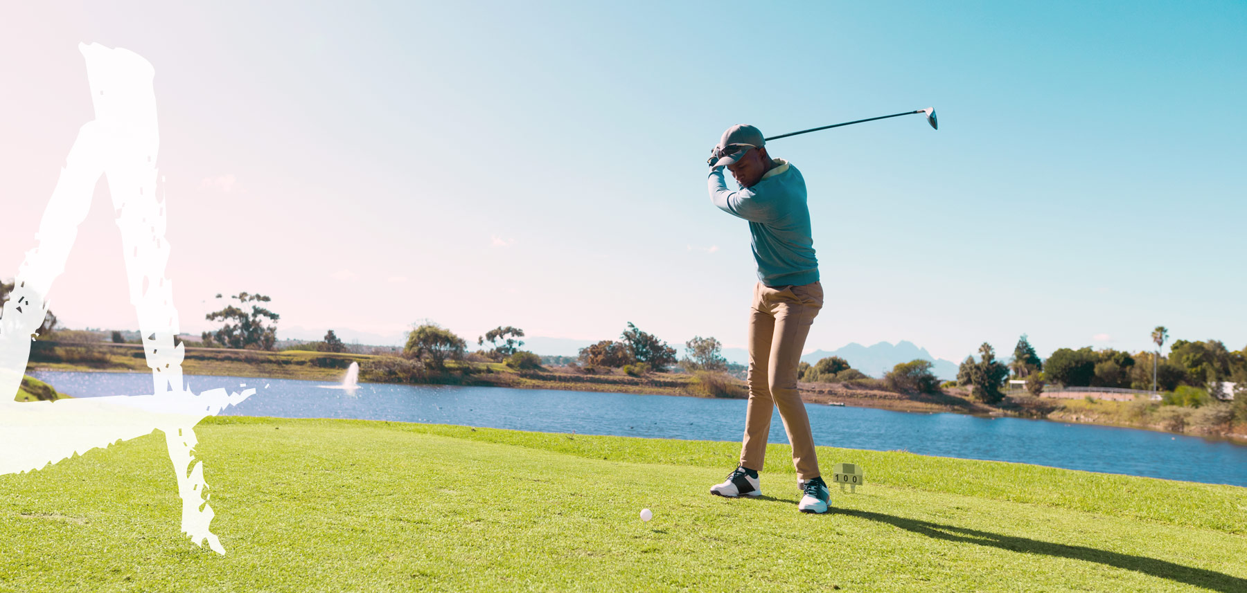 Golfer mid-swing on a waterfront course